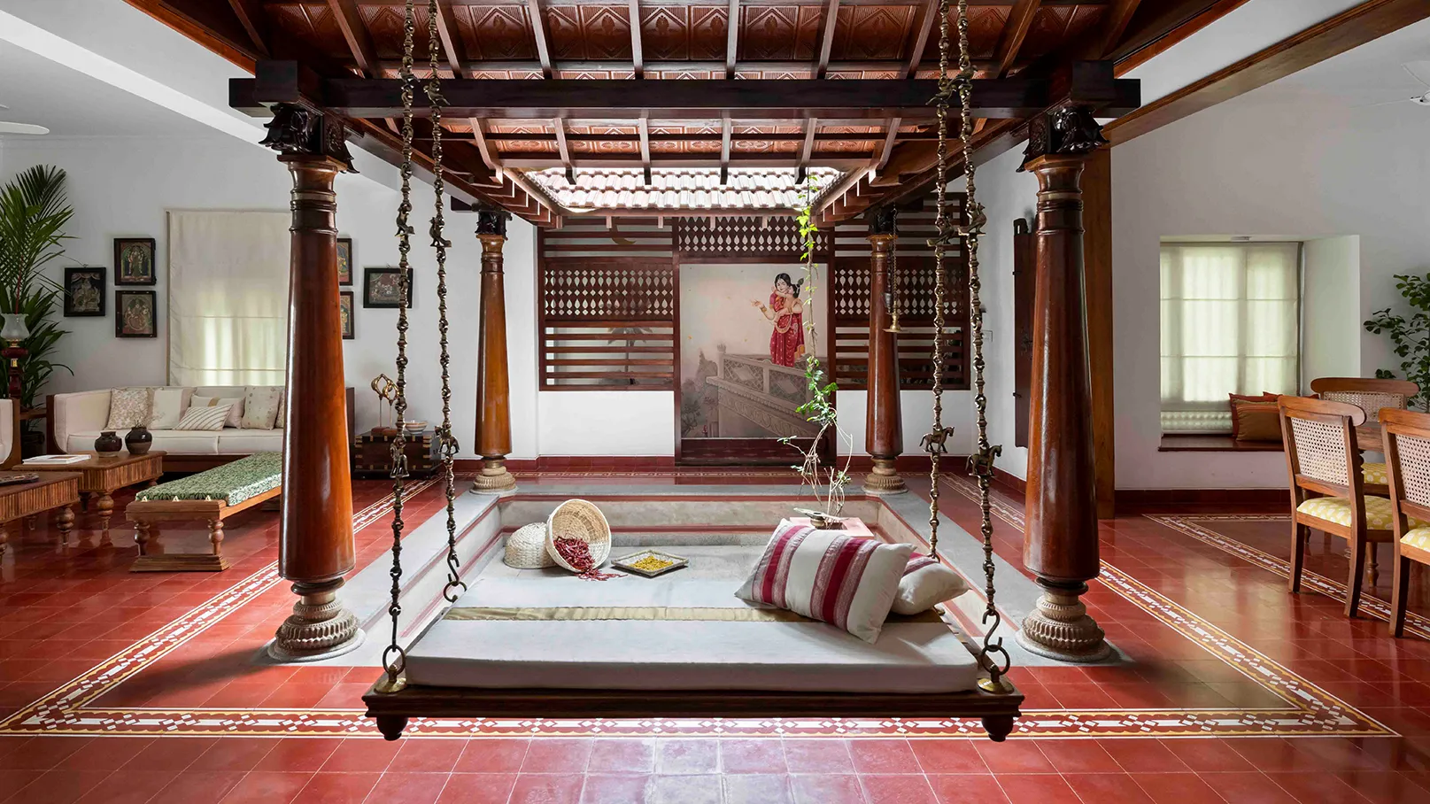 Traditional Kerala style Poomukham entrance with carved teak wood pillars and an Aattukattil swing—heritage NRI home in Palakkad.